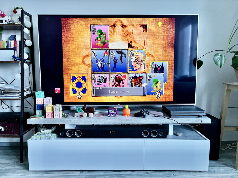 Final Fantasy VII being played on a TV. On the screen there is an ongoing Triple Triad game.